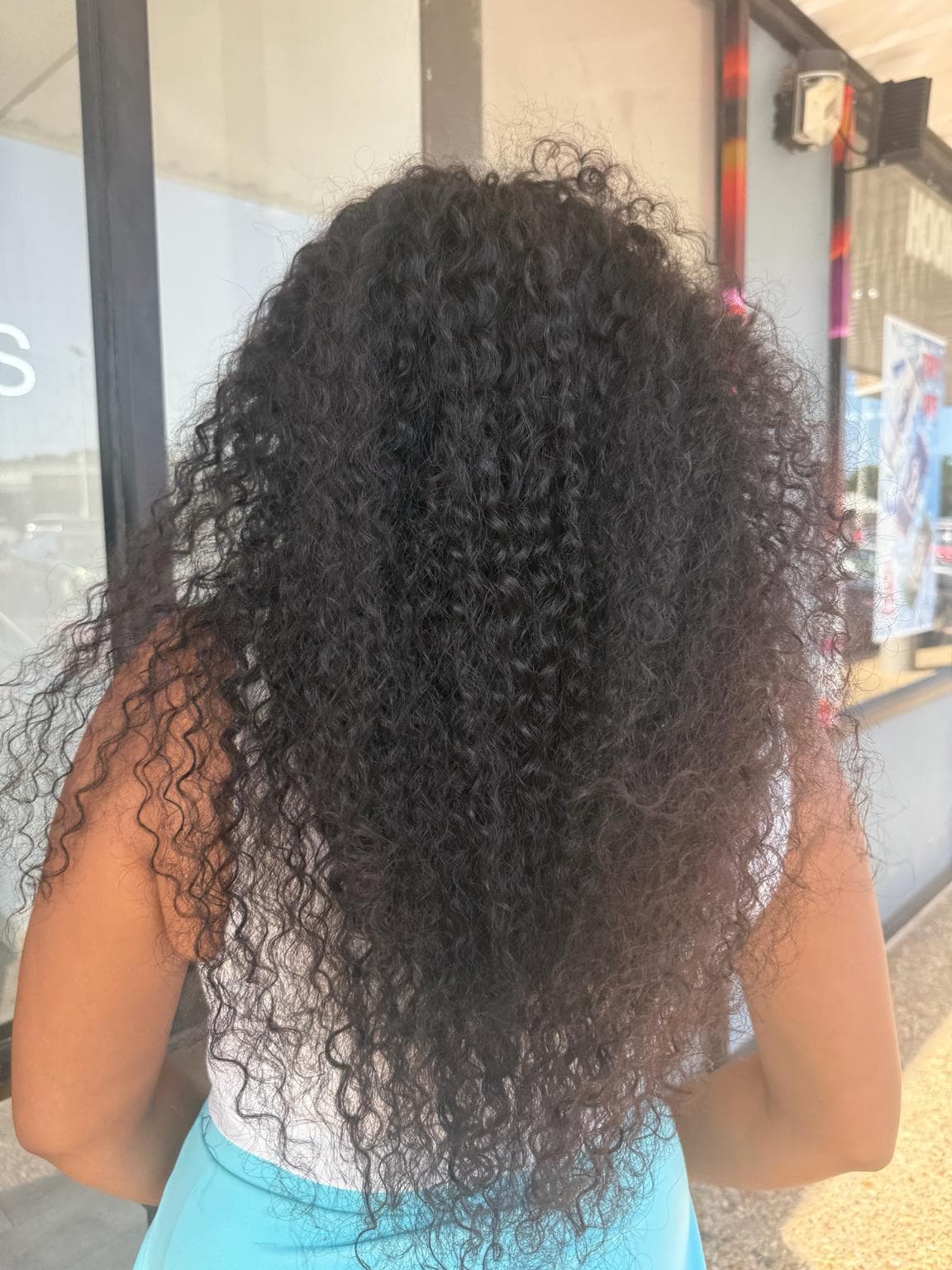 Long black neat feed in cornrows soft curly half wig back view